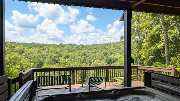 A hot tub with a view of a forested landscape.