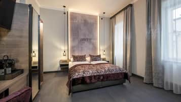 Une chambre d’hôtel moderne avec un grand lit, des tables de chevet, un miroir et un panneau fixé au mur.