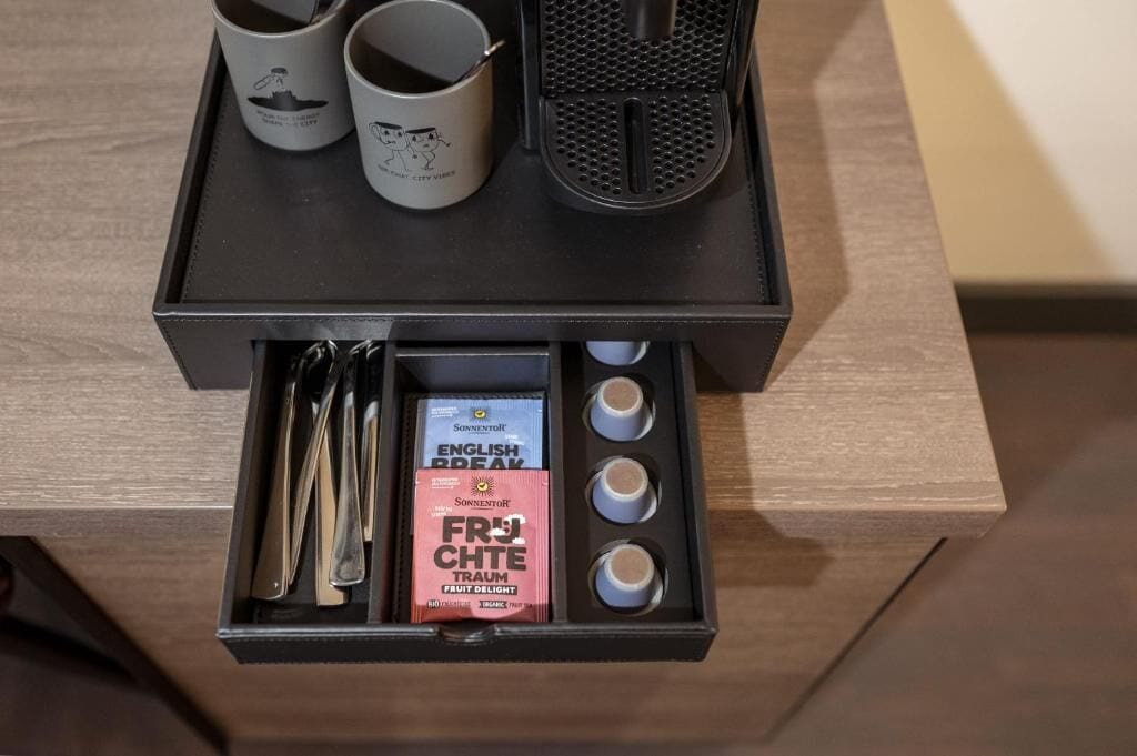 Een dienblad met een doos vol ingrediënten voor een Engels ontbijt, een koffiezetapparaat en twee mokken.