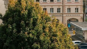 A building with a pink facade, arched windows, and a sign that reads 'HOTEL'. - HOTEL andrä (Salzburg)