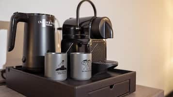 Une machine à café, une bouilloire et deux boîtes de conserve sur un plateau.