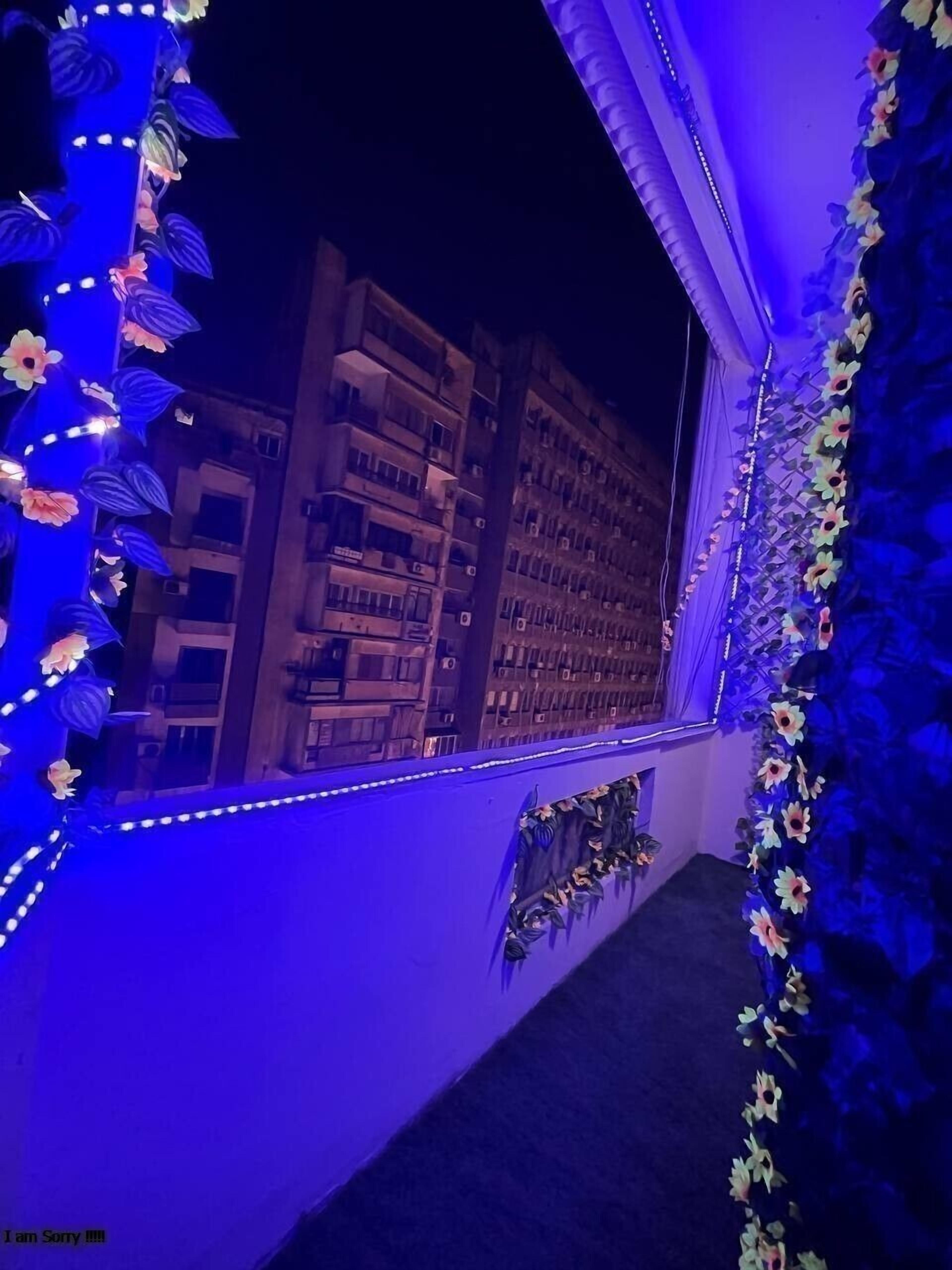 A room with a large window, decorated with blue LED lights and floral designs.