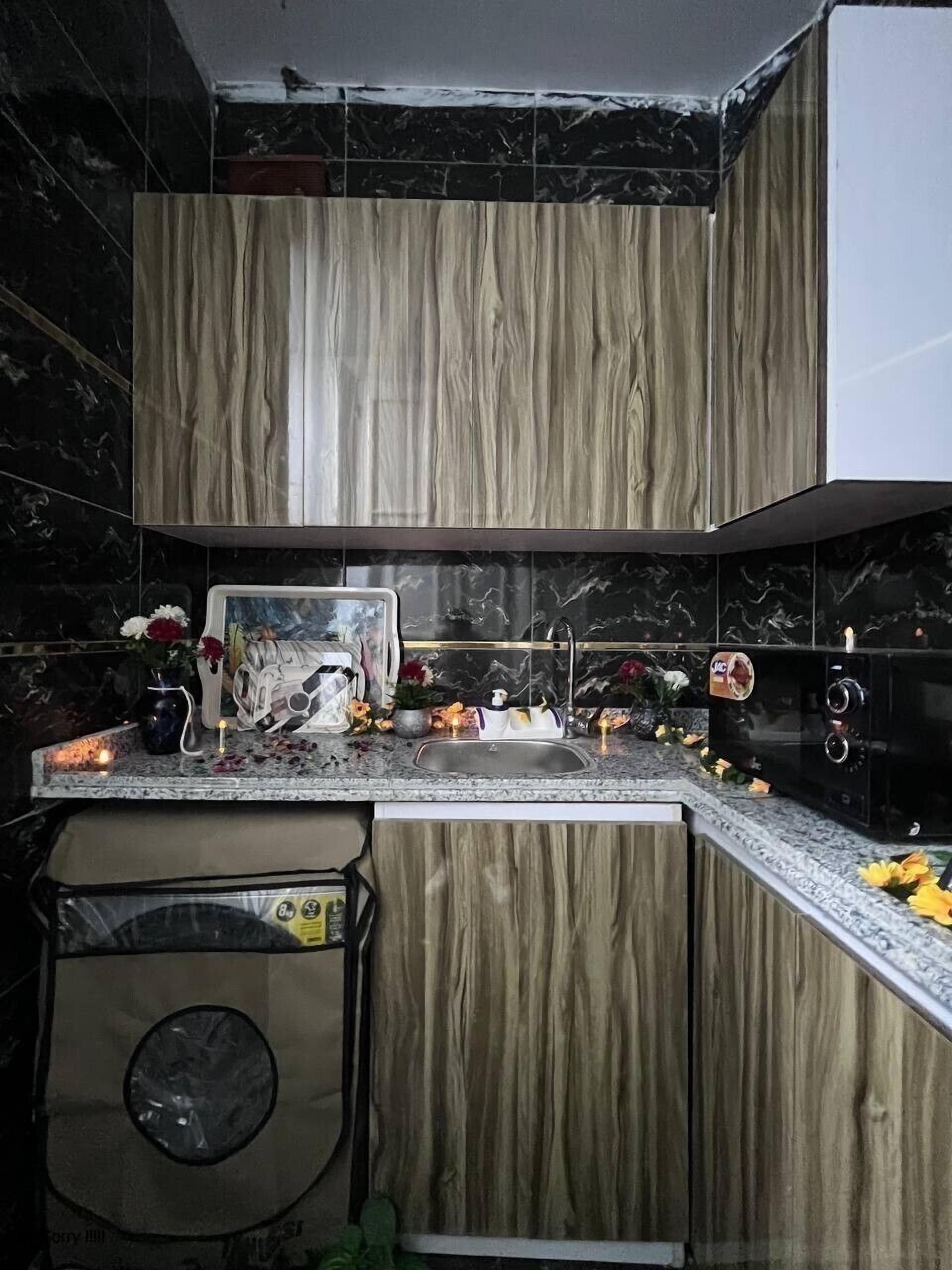 A modern kitchen with a marble backsplash, wooden cabinets, and a granite countertop.