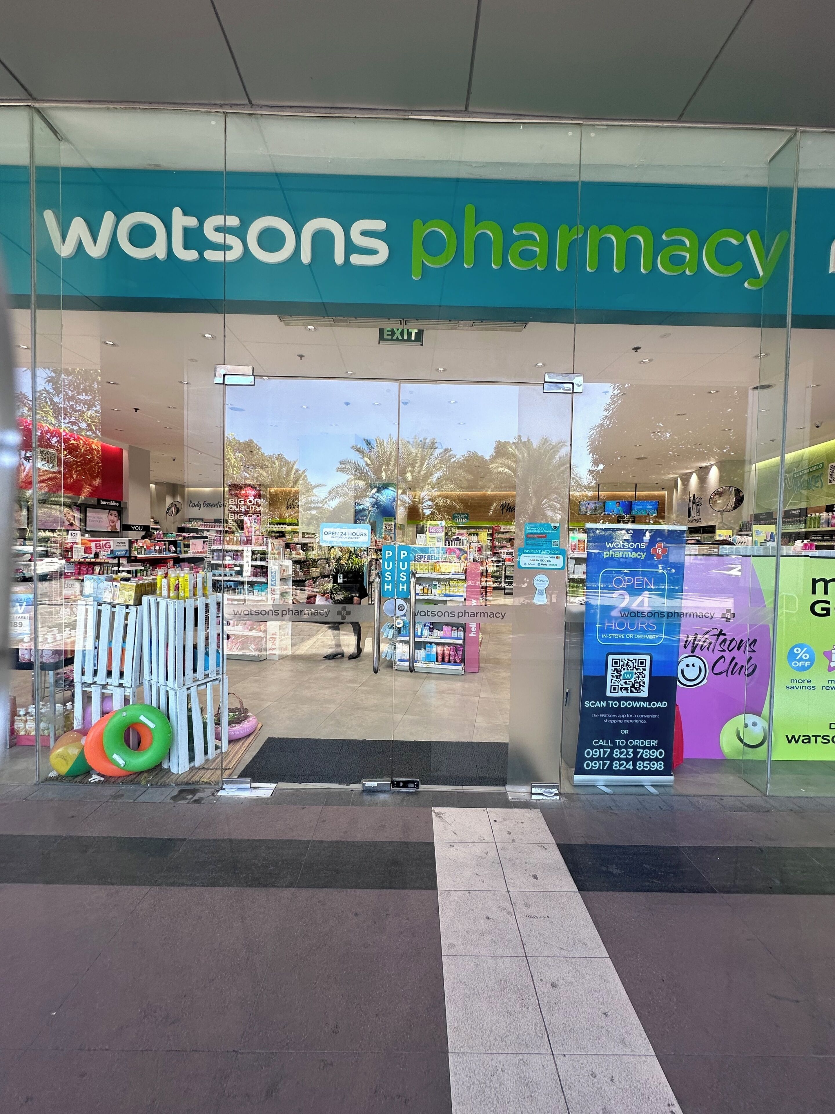 A pharmacy entrance with a sign reading 'Watsons Pharmacy.'