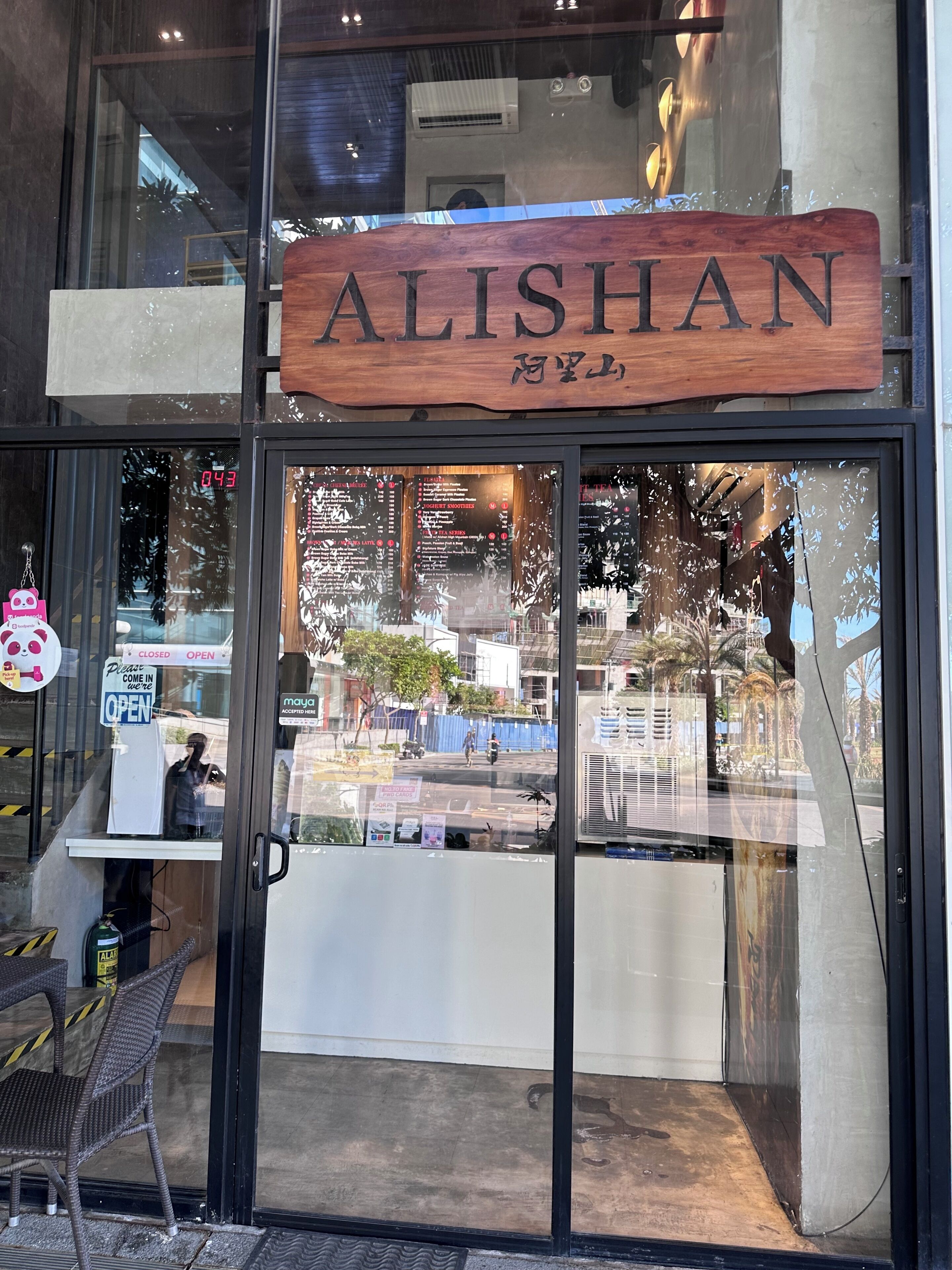 Una fachada con un letrero de madera que dice 'ALISHAN'.