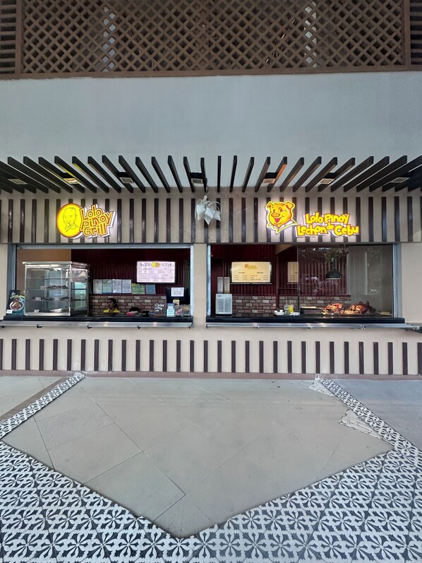 Un restaurant avec deux enseignes, une vitrine et un sol à motifs.