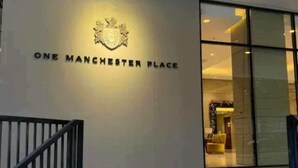 A modern building entrance with a sign reading "ONE MANCHESTER PLACE".