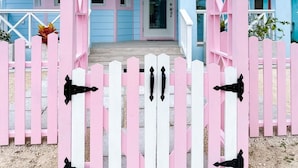 A pink and white wooden gate with a porch leading to a blue house. - Rest Ashore, BRAND NEW 2-bedroom cottage in Spanish Wells!FREE golfcart (Spanish Wells)
