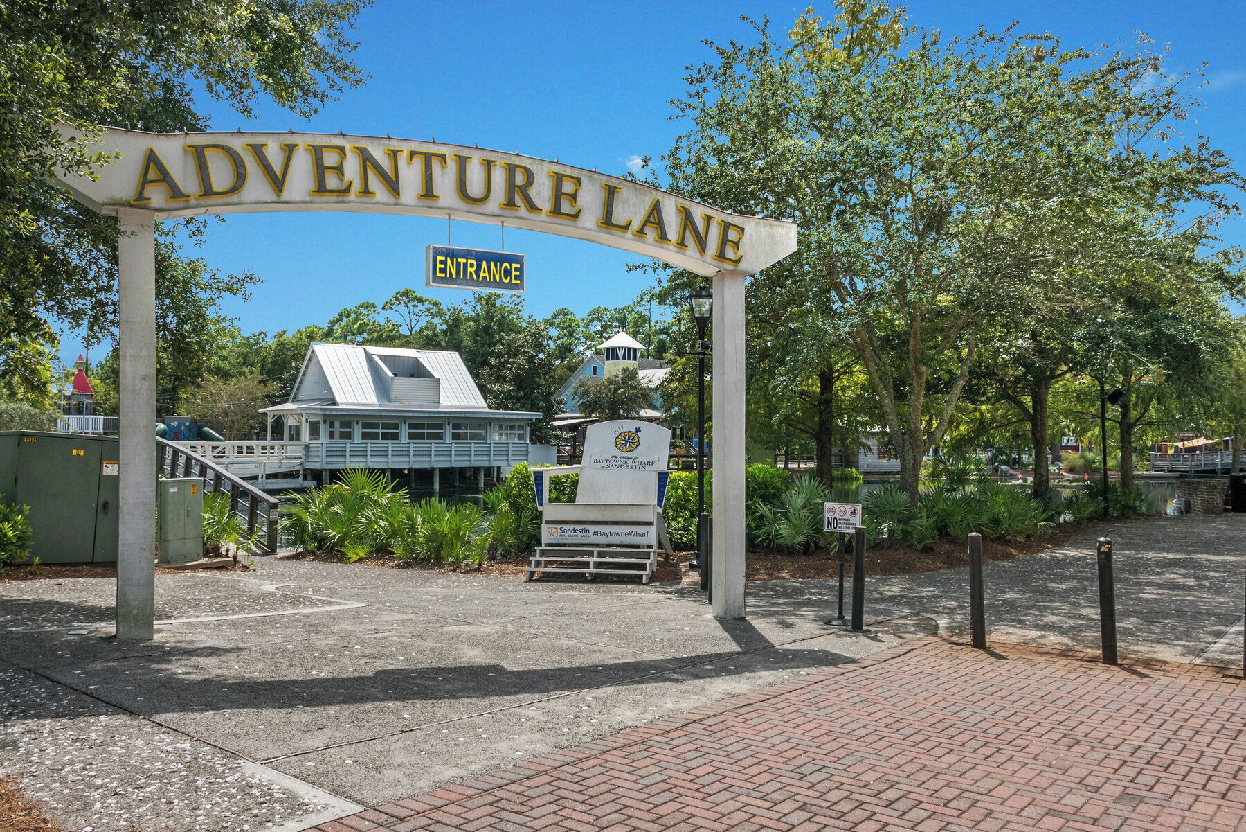 Een bord met daarop 'ADVENTURE LANE', met een gebouw op de achtergrond.