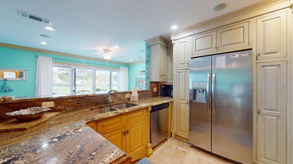 A modern kitchen with granite countertops, stainless steel appliances, and wooden cabinets. - Augusta Village Sandestin by Gibson BR  (Miramar Beach)