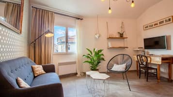 Appartement, uitzicht op de stad | Woonruimte | Een 39-inch flatscreentelevisie met kabelzenders en Netflix