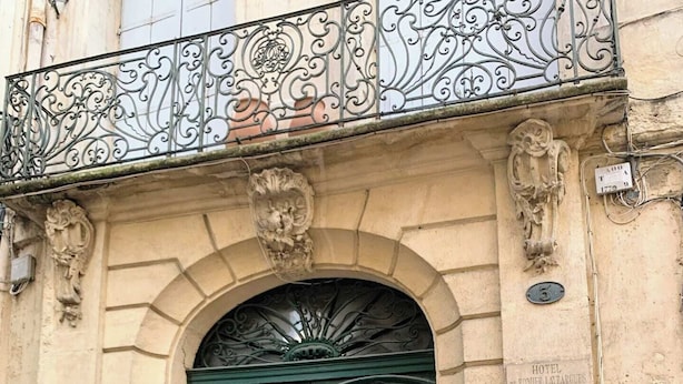 A historic building with a double green door, ornate metalwork above the door, and a plaque indicating it is the Hotel de Pomier. - Home Chic Home Les Toits de l'Argenterie (Montpellier)