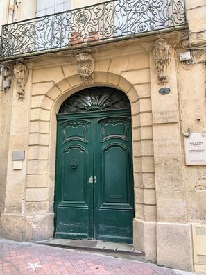 A historic building with a double green door, ornate metalwork above the door, and a plaque indicating it is the Hotel de Pomier. - Home Chic Home Les Toits de l'Argenterie (Montpellier)