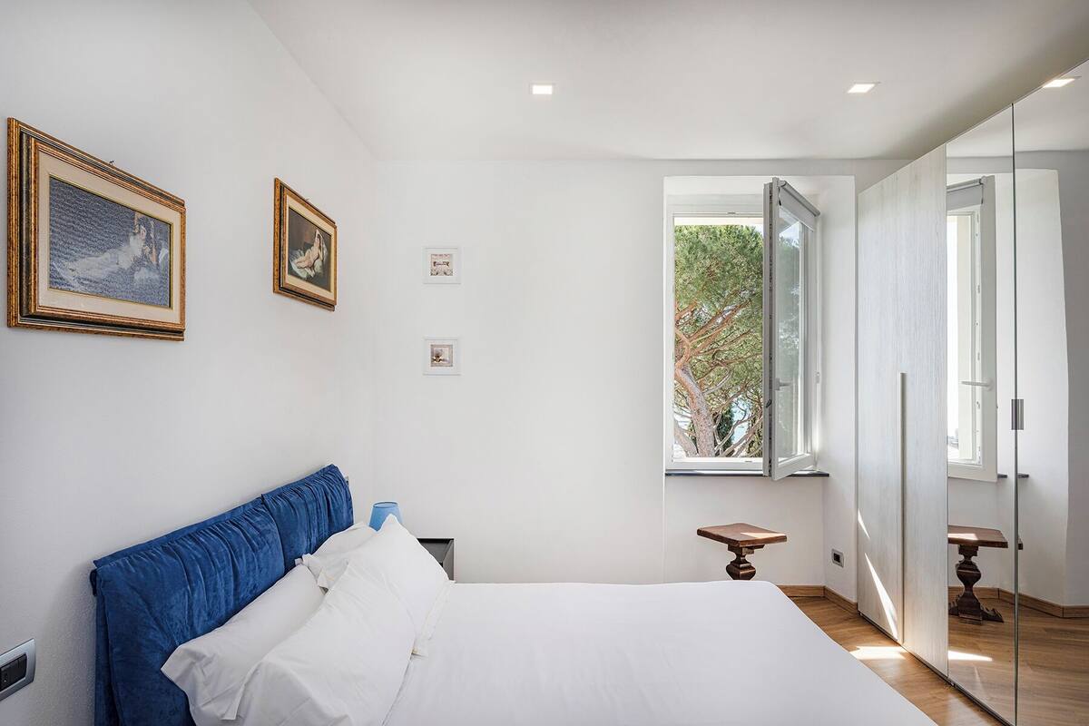 A bedroom with a bed, a window, and a door.