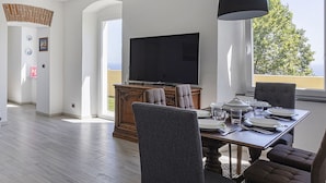 En moderne spiseplads med et stort fjernsyn, behagelige siddepladser og udsigt til det fri.