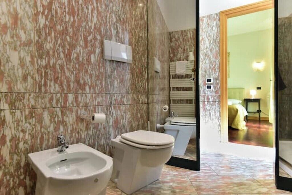A bathroom with a bidet, toilet, and a sink.
