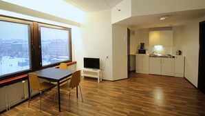 A compact living space with a dining area, a small kitchenette, and a large window offering a city view. - Forenom Apartments Rauhankatu 16 (Lahti)