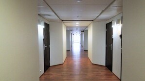 A long, narrow hallway with wooden flooring and white walls. - Forenom Apartments Rauhankatu 16 (Lahti)