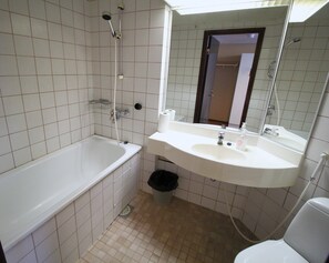 A bathroom with a bathtub, a sink, and a toilet. - Forenom Apartments Rauhankatu 16 (Lahti)