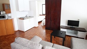 A modern apartment with a kitchenette, a dining area, a living room with a sofa, and a TV. - Forenom Apartments Rauhankatu 16 (Lahti)