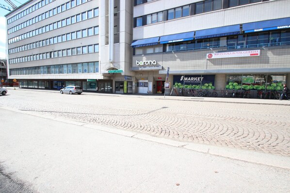 A multi-story building with a barana restaurant on the ground floor, a market on the second floor, and a parking area with bicycles. - Forenom Apartments Rauhankatu 16 (Lahti)
