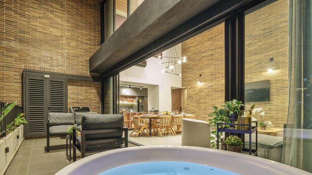 Un patio exterior moderno con hidromasaje, zona de estar y comedor.