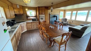 A spacious kitchen with wooden cabinets, a dining table, and a built-in oven.