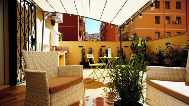 A cozy outdoor seating area with wicker furniture and potted plants.