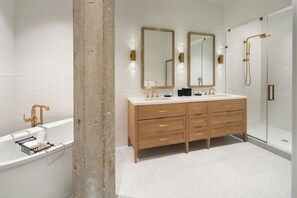 Un bagno moderno con doppio lavabo, vasca da bagno e cabina doccia.