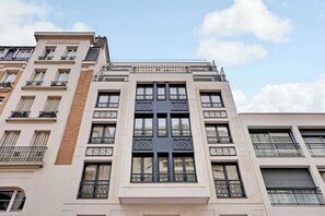 A multi-story building with a central atrium, large windows, and balconies.