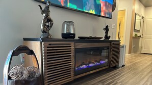 Una sala de estar moderna con un mueble de madera para el centro de entretenimiento, un televisor de pantalla plana y un acuario.