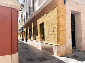 A building with a beige stone facade, multiple windows, and a corner entrance. - Urania Cádiz Apartments by Soho Boutique (Cádiz)