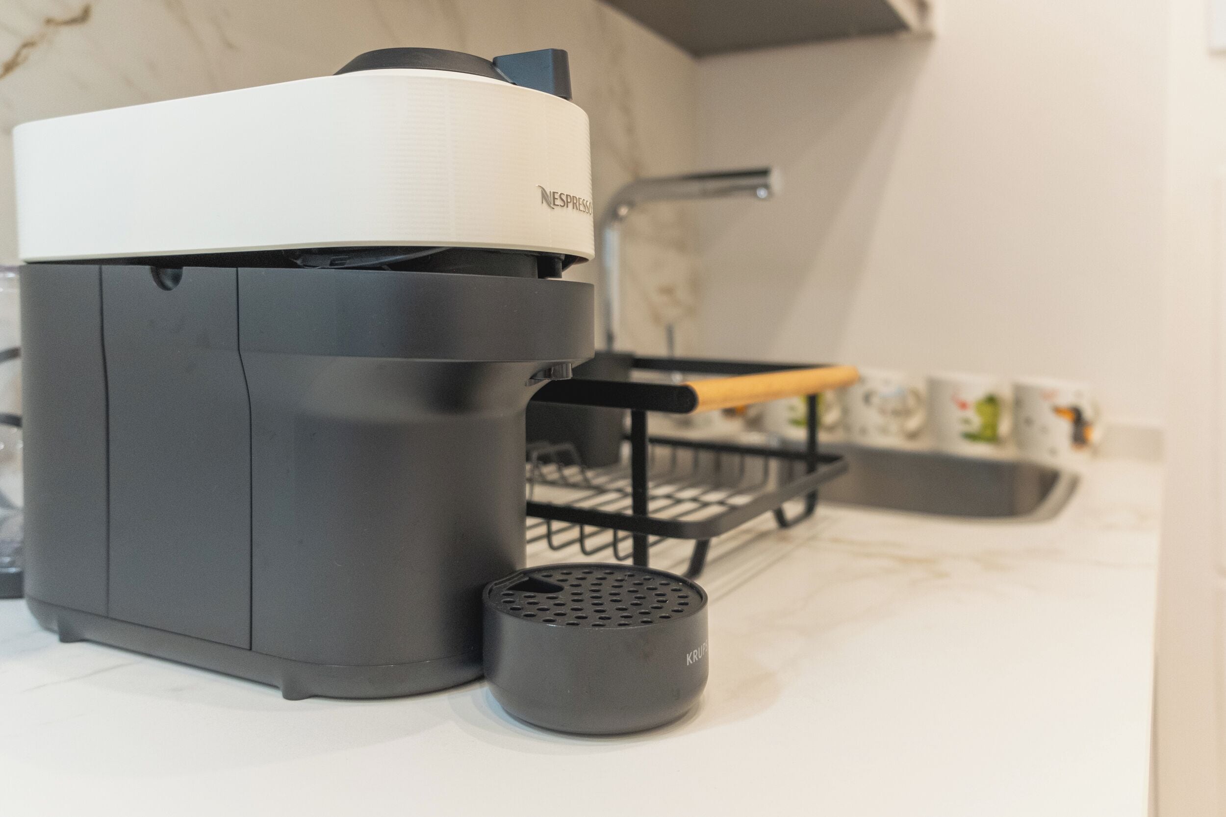 Une cuisine équipée d’une machine à café, d’une bouilloire et d’un chauffe-bouilloire sur le plan de travail.
