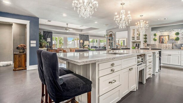 A spacious kitchen with a large island, white cabinetry, and a chandelier. - SPEND YOUR SPRING BREAK IN A HOT TUB/HEATED POOL on the ISLAND! (Galveston)