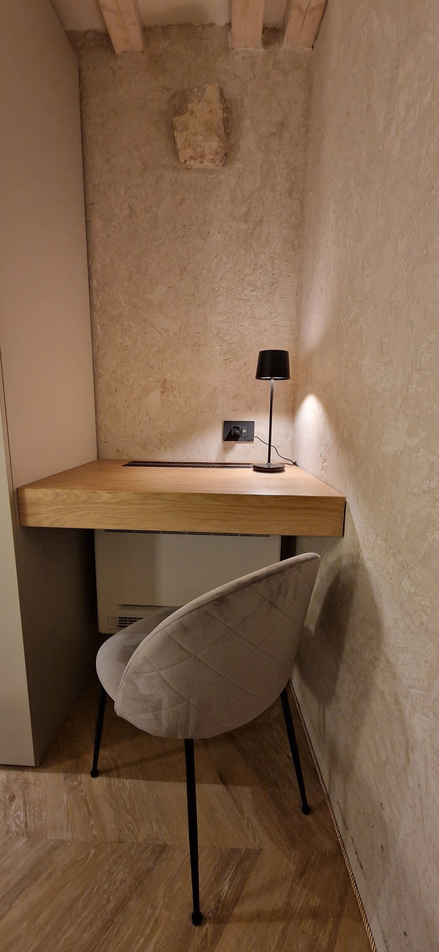 A corner desk with a chair, a lamp, and a small heater.