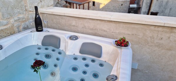 A hot tub with a rose, a bottle of champagne, and a plate of strawberries. - VIU2 Castle (Kastela)