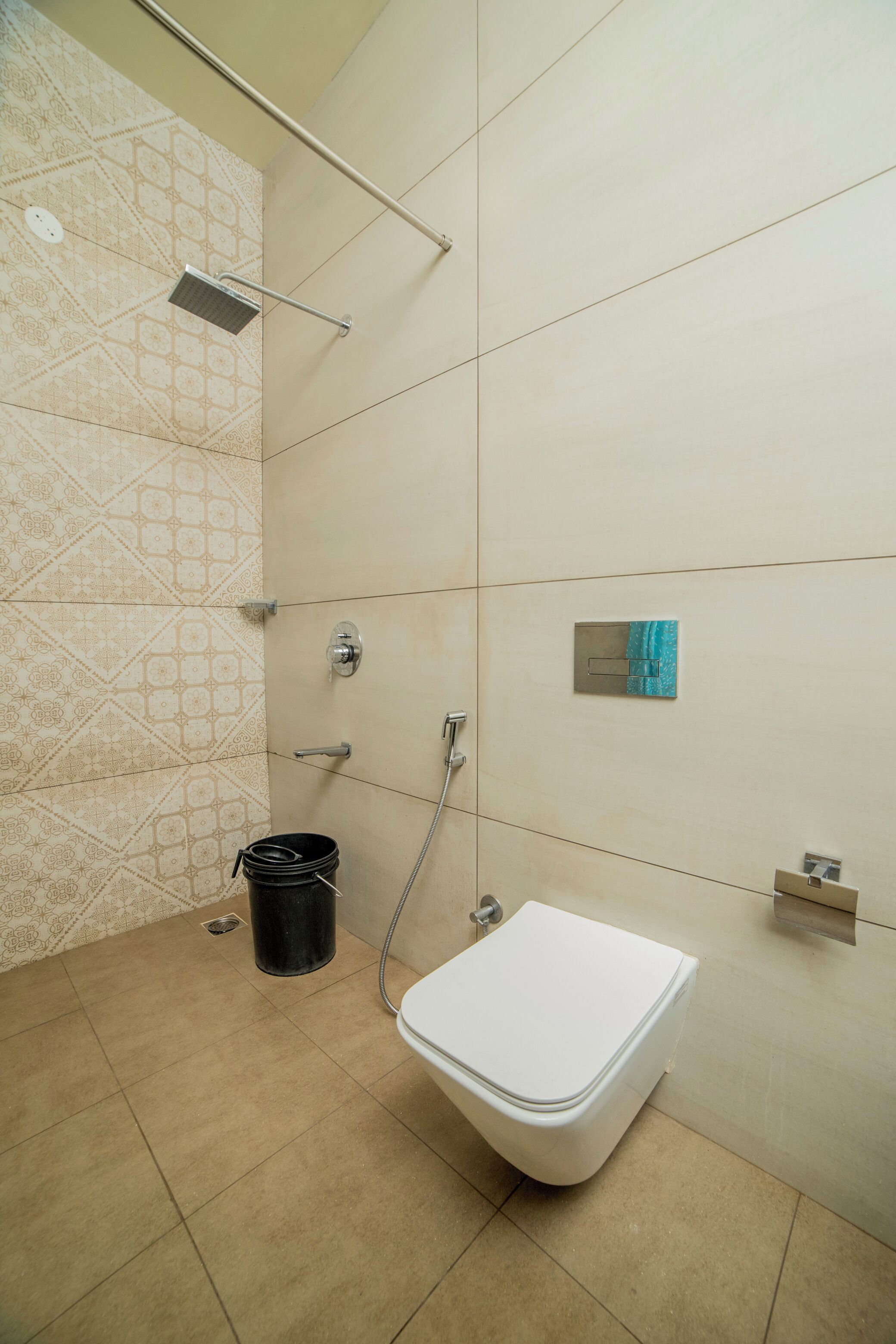 Un baño con inodoro, ducha y perchero para toallas.