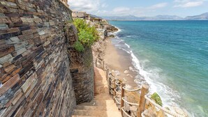 A coastal staircase leading to a beach with a stone wall on one side and a clear view of the sea. - Villetta Ficarazzi in Ficarazzi (Ficarazzi)