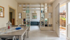 A spacious living area with a dining table, a sofa, and built-in shelving with decorative items. - Villetta Ficarazzi in Ficarazzi (Ficarazzi)