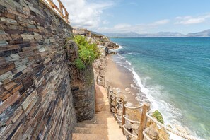 Uma passarela costeira com muro de pedra e vista para o mar.