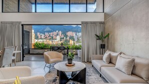 A modern living room with a city view, a balcony, and a dining area. - Luxe & bright ap in poblado /AC - Morph1401 (Medellín)