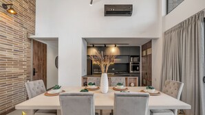 A dining area with a long table, grey upholstered chairs, and a central white vase. - Luxe & bright ap in poblado /AC - Morph1401 (Medellín)