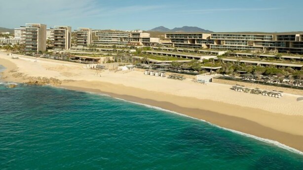 A coastal hotel with multiple buildings, a sandy beach, and a view of the ocean. - The Club at Solaz (San José del Cabo)