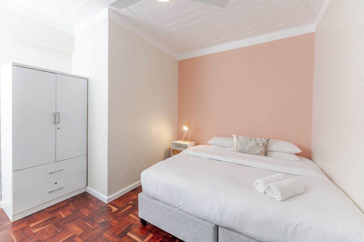 Une chambre à coucher avec un lit, une table de chevet et une armoire.