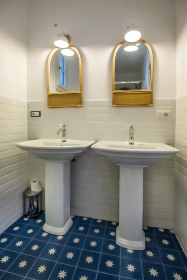 A bathroom with two sinks, white tiled walls, and a blue star-patterned floor. - Maison d'Orange - La Pinede (Saint-Tropez)