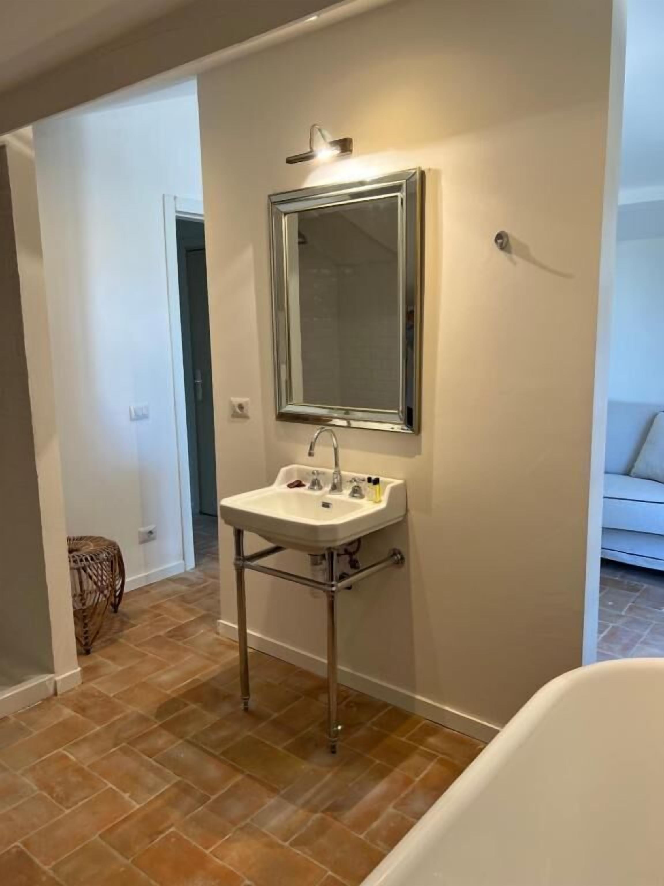 A bathroom with a white sink, a mirror, and a shower.