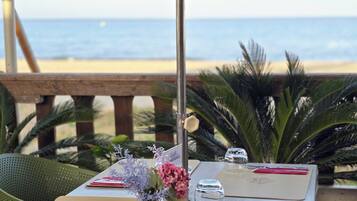 Mesa dispuesta para dos con vista a la playa y al océano.