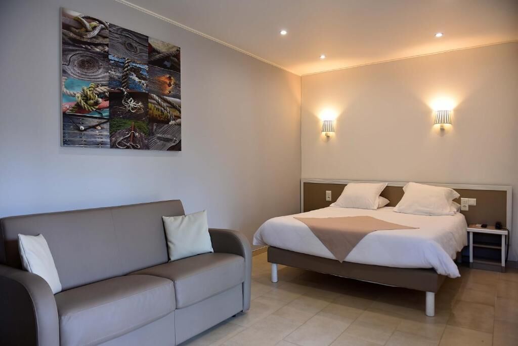 Una habitación de hotel moderna con una cama, un sofá y un cuadro abstracto grande en la pared.