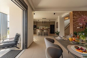 A modern kitchen with a dining area, a staircase, and a view of the outdoors. - Private & Modern 4BR Villa, Heated Pool, Jacuzzi, and Gaming room, Near Zadar (Bibinje)