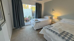 A hotel room with two beds, a window with curtains, a lamp, and a view of the outside. - Tranquil Cottage Retreat - Malanshof, Randburg (Johannesburg)